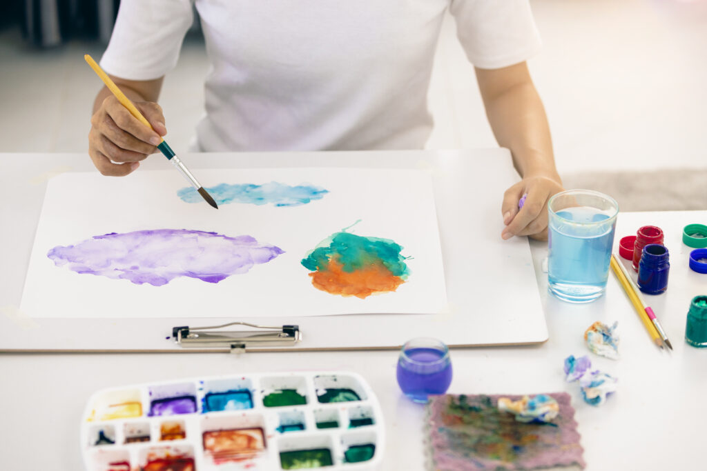 person painting with watercolors